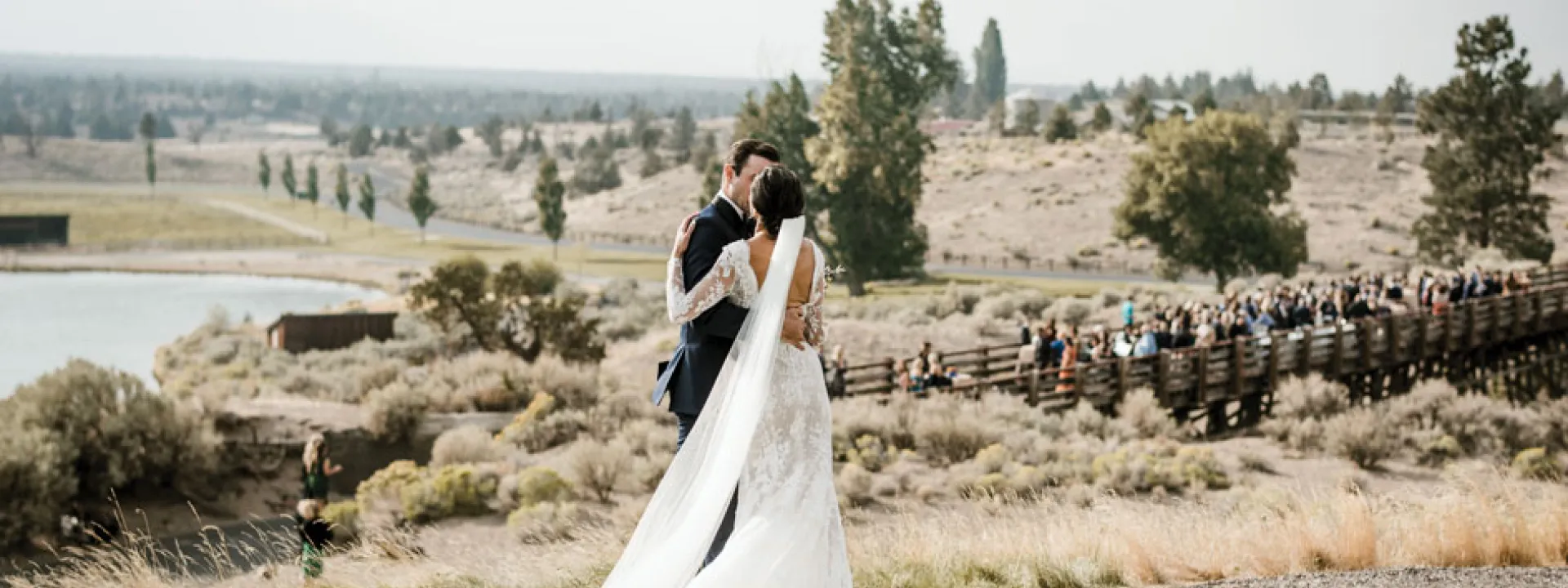 The hills and valleys of Central Oregon span beyond the couple as they pose at Brasada Ranch