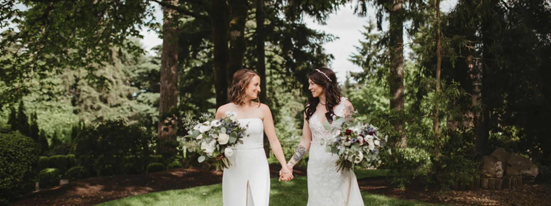 Erika and Stacey standing under a grove of pines at a private estate. 